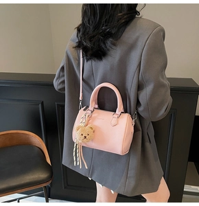 Rear view of model with pink lychee leather Boston bag and cute bear pendant charm