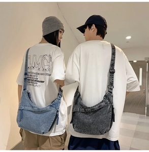 Detail of denim crossbody crescent bags in light blue and charcoal grey with adjustable straps