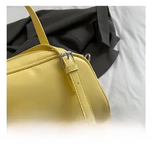 Gros plan détaillé sur la boucle en métal argenté d'un sac à main en cuir grainé jaune