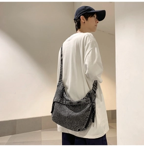 Detail of large dark grey canvas crossbody bag showing texture and side zipper pocket