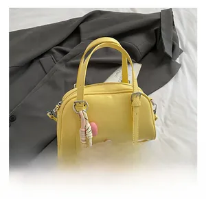 Détail d'un sac à main en cuir PU jaune vif avec pendentif corde et cœur rose