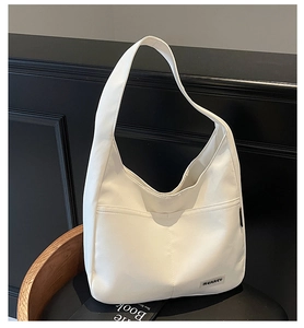 Detail view of a beige minimalist hobo shoulder bag with brand woven label on textile