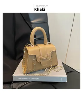 Makroansicht der khakifarbenen matten Lederhandtasche mit Goldbeschlägen und Kette