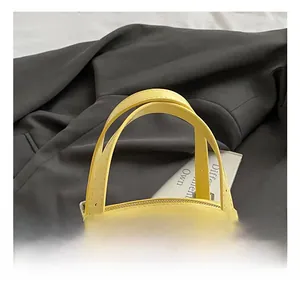 Détail d'un sac à main jaune vif montrant la quincaillerie argentée et les doubles anses