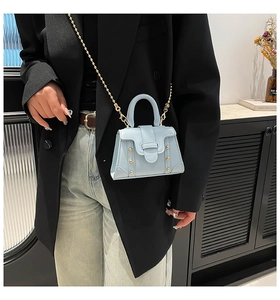 Details der hellblauen Mini-Tasche mit Goldnieten und abnehmbarer Kette