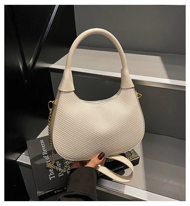 Detailansicht der weißen Handtasche mit Webstruktur, Goldkette und Reißverschluss