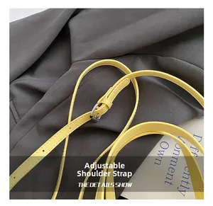 Détail de la bandoulière réglable en cuir jaune vif avec boucle argentée et surpiqûres