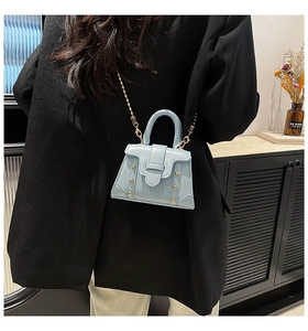 Dettagli della mini borsa quadrata azzurra con borchie dorate e catena in metallo