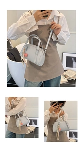 Détail du sac à main en cuir verni bleu clair avec breloque cœur rose et foulard en soie