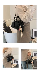 Gros plan sur un sac à main noir brillant avec breloque cœur et pompon tissé