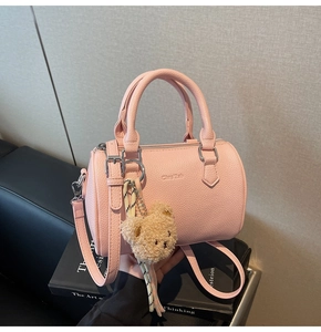 Pink cylinder barrel bag in litchi grain leather with cute brown teddy bear keychain