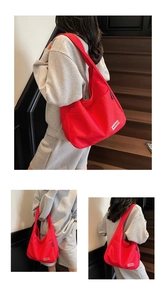 Detail of red canvas tote bag showing the textured material and brand label