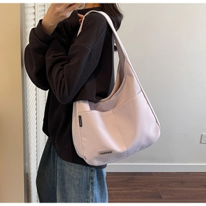 Detail view of large capacity pink hobo bag with side brand label and front pocket