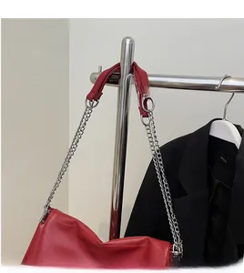 Detailed close-up of a silver chain strap with red leather shoulder pad on a bag
