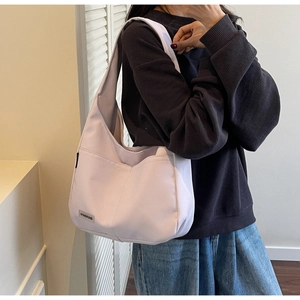 Close-up of a light purple tote bag with functional side pocket and a fabric logo label