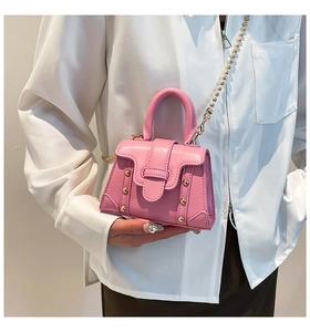 Detailansicht der rosa Leder-Vierecktasche mit Goldnieten und Kugelkettengurt
