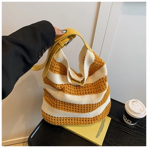 Detailed close-up of yellow and beige striped woven hobo bag with leather strap handle