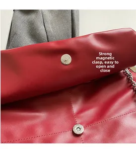 Close-up of red leather bag with strong silver magnetic snap closure and chain strap