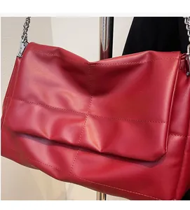 Close-up of red quilted leather shoulder bag featuring stylish silver chain strap detail