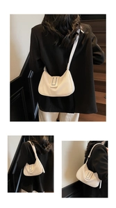 Détail du sac sous le bras en forme de croissant blanc cassé avec boucle en métal argenté