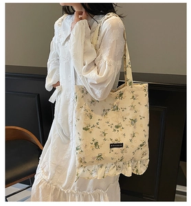 Détail du sac cabas floral avec nœuds, ourlet à volants et étiquette Romance