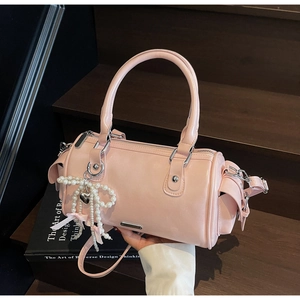 Detail of pink patent leather boston bag with pearl bow charm and silver hardware