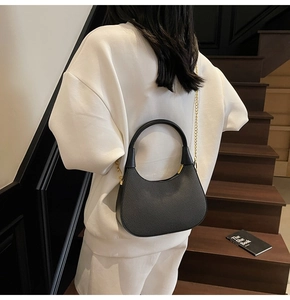 Detailansicht der schwarzen gewebten Hobo-Tasche mit Goldkette und Lederstruktur