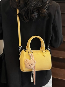 Chic yellow lychee leather Boston bag with bear charm and adjustable shoulder strap