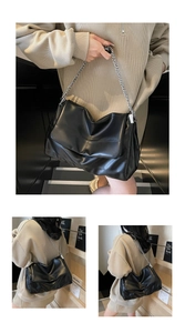 Detail of minimalist black patent leather bag with thick silver metal chain strap