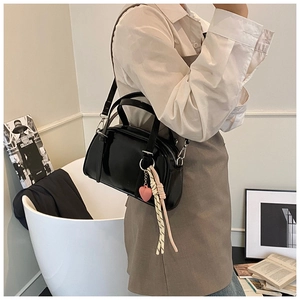 Sac bowling noir poli avec breloque cœur rose et détails de sangle tressée de près