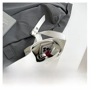 Vue intérieure du sac blanc à rivets montrant le rangement des cosmétiques et téléphone