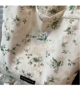 Détail du sac cabas floral avec applique papillon en dentelle et bordure à volants