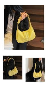 Détail du sac à main jaune en cuir grainé avec boucle métallique en forme de U argentée