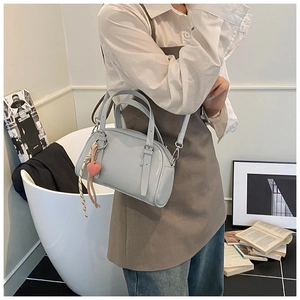 Détail du sac bowling bleu clair brillant avec pendentif cœur et foulard sur mannequin