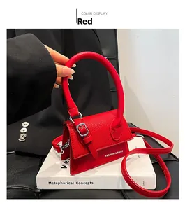 Détail du mini sac à main rouge texture litchi avec poignée épaisse et logo imprimé blanc