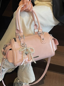 Pink glossy patent leather Boston bag with pearl bow charm and adjustable strap