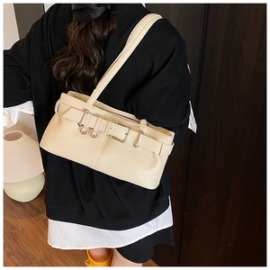 Close-up of beige lychee texture leather shoulder bag with vintage silver buckle detail