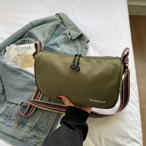 Detail of olive green nylon dumpling bag with multi-color striped wide shoulder strap