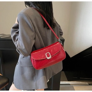 Detail of red patent leather shoulder bag with vintage silver oval buckle and strap