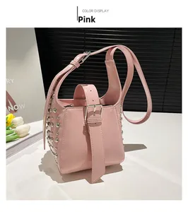 Détail du sac seau en cuir verni rose avec rivets argentés et large poignée à boucle