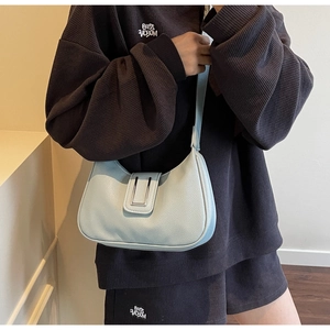 Détail du sac en cuir bleu clair à motif litchi avec boucle argentée et forme en demi-lune