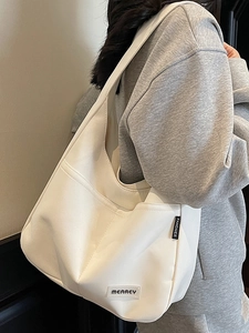 Minimalist large capacity white canvas tote bag with front pockets on a model
