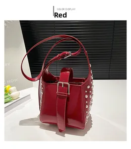Détail du sac seau en cuir verni rouge avec clous métalliques argentés et boucle