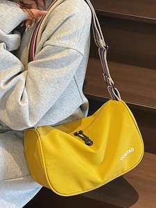 Fashionable yellow canvas crossbody dumpling bag with striped wide strap and logo print