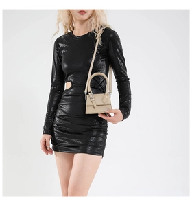 Mini sac à main kaki avec texture cuir porté par un mannequin en robe noire à découpes