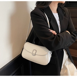 Chic white leather small square crossbody bag shown worn by a model in black blazer