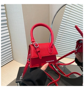 Détail du mini sac à main rouge en cuir grainé avec boucle et bandoulière amovible