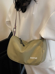 Olive green nylon dumpling crossbody bag with striped strap shown on a model