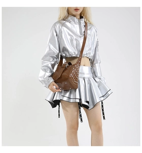 Détail d'un sac à bandoulière marron style punk avec rivets argentés et cuir brillant