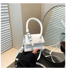 Détail du mini sac blanc avec poignée ronde et texture en cuir grainé élégante
